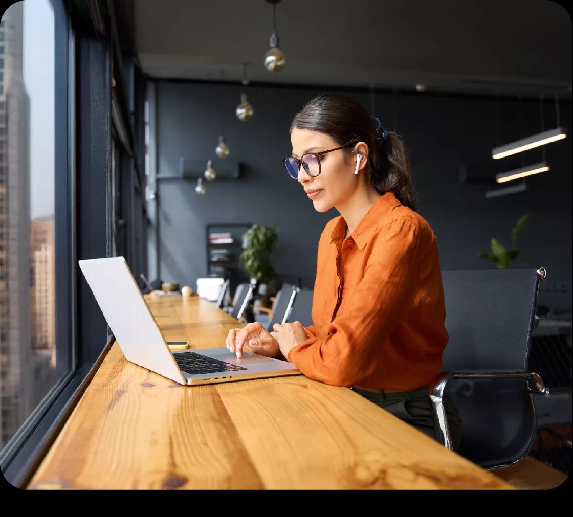 Treasury manager at a Kyriba customer working from her laptop