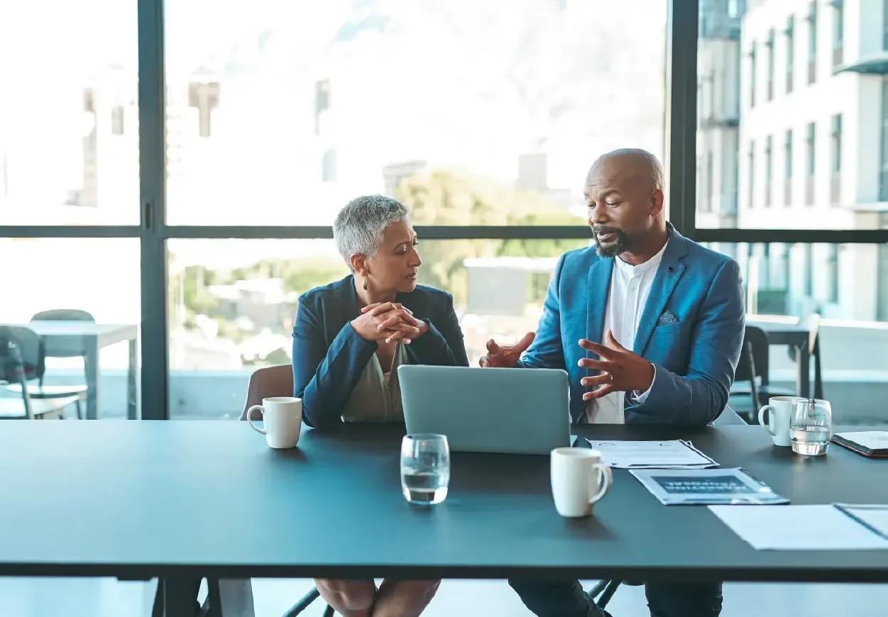 Image of two finance leaders reviewing reports from Kyriba together
